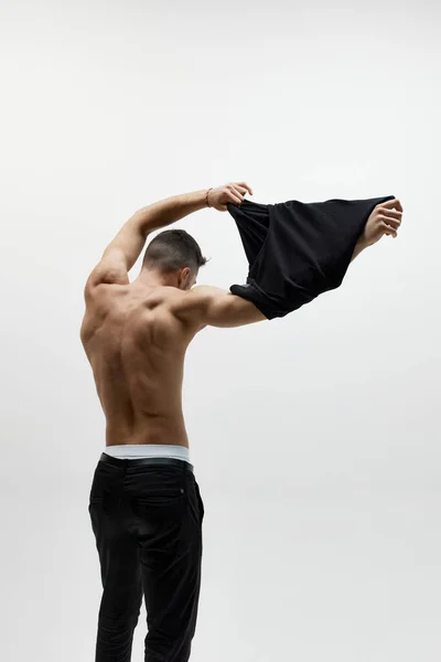 男人味拍的肌肉年轻男子脱下T恤孤立在白色工作室背景 男人装扮成赤身裸体单色 男子健康 美容美发 身体和皮肤护理 健康的概念 — 图库照片