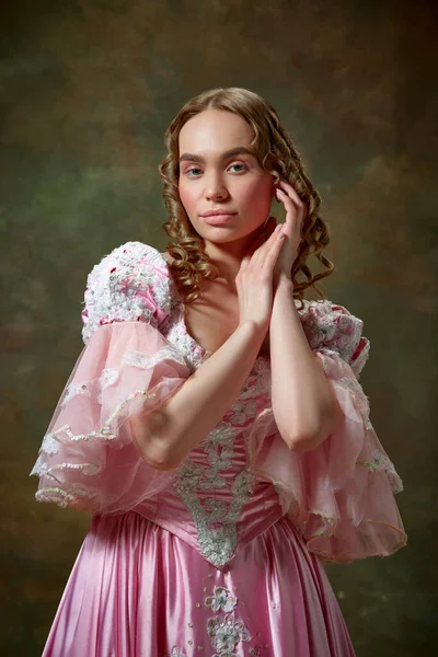 stock image Medieval charming queen. Shot of beautiful woman wearing vintage pink dress and standing with folded hands over vintage texture background. Concept of medieval, beauty, old-fashioned clothes, ad