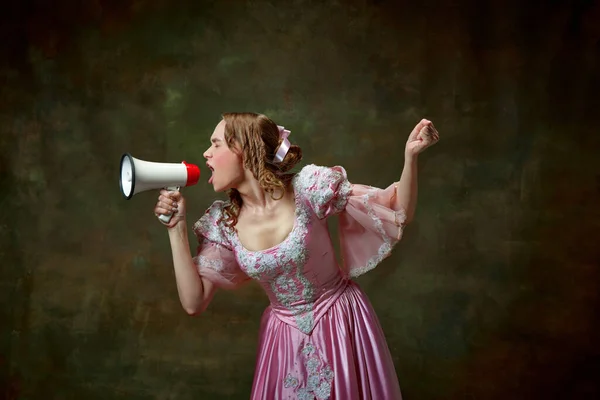 Attention, please. One charming blond princess wearing fancy pink dress screaming through megaphone over vintage texture background. Concept of news, sales medieval, beauty, old-fashioned clothes, ad