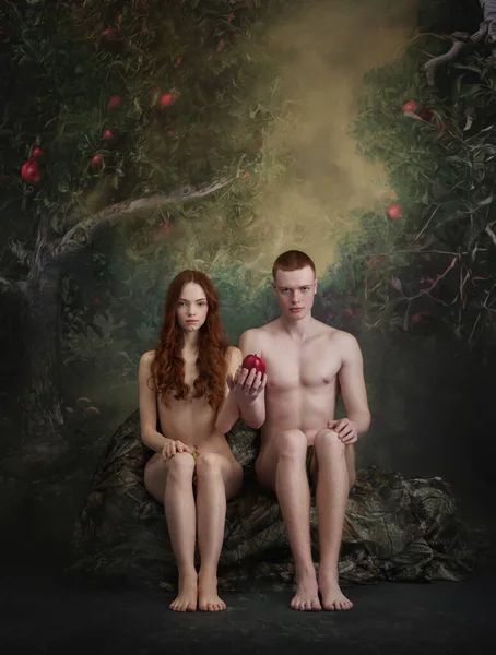 Forbidden fruit. Cinematic portrait of new Adam and Eve. Young man and woman sitting and looking at camera over vintage tapestry background. Art, creativity, eras comparison concept