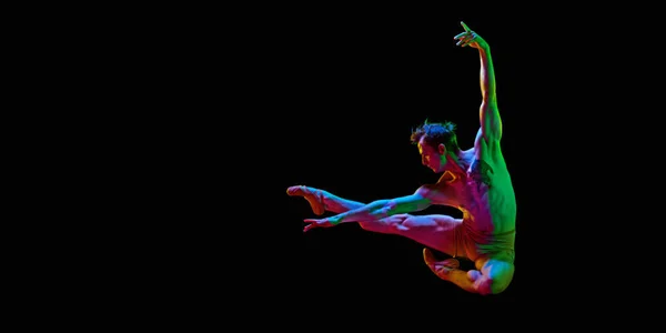 自由よ 1人の若い男とバナー バレエダンサーはネオンで暗いスタジオの背景に空中でジャンプします テキストのためのスペースをコピーします コンテンポラリーダンスのコンセプト — ストック写真