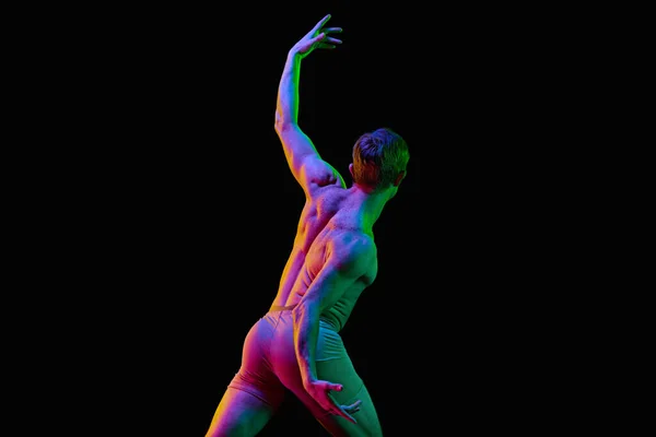 感情的な動きだ ある若いハンサムな男は ダンサーの裸の服を着てネオンで暗いスタジオの背景に感情を持って踊ります 現代バレエ グレースアートプロスポーツのコンセプト — ストック写真