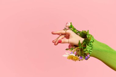Bahar Moda Haftası. Zarif bir kadın eli olan portre pembe stüdyo arka planında çiçekleri içeride tutuyor. Doğa kavramı, çiçek mevsimi, şık kıyafetler, güzellik, sanat, yaratıcılık, reklam