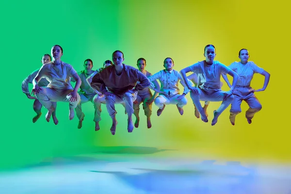 ティーンエイジャーのグループと肖像画 若いダンサーがネオンの光の中でグラデーションの背景を一緒にジャンプします 現代のフリースタイルダンス 現代美術 創造的なライフスタイルの概念 — ストック写真