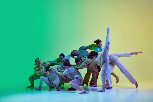 実験舞踊 ダンサーのダンスグループの振付訓練 ネオンのグラデーションを背景にした少女たち 現代のフリースタイルダンス 創造的なライフスタイルの概念 現代舞踊 — ストック写真