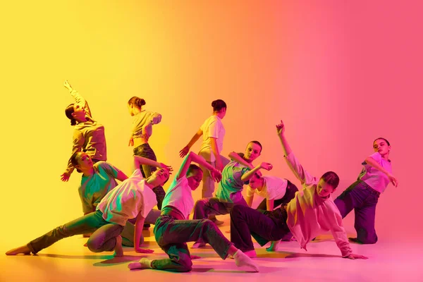 女子ダンス部 10代の若者たちのグループは ネオンでピンクと黄色のグラデーションの背景で感情的に踊る 現代のフリースタイル 現代美術 創造性 広告の概念 — ストック写真