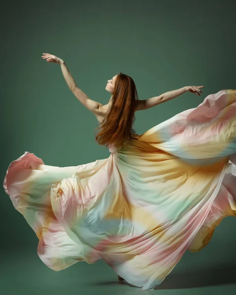 シルクのドレスを着たモダンなバレエ 1人の若い豪華なバレリーナ 暗い緑のスタジオの背景の上の生地で優雅に踊る若い女の子 美の概念古典バレエ芸術 — ストック写真
