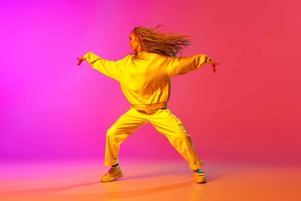 1人の魅力的な女の子と肖像画 ネオンの光のグラデーションピンクの背景の上で踊るドレッドロックを持つダンサー コンテンポラリーダンスのスタイル アート インスピレーション 広告の概念 — ストック写真