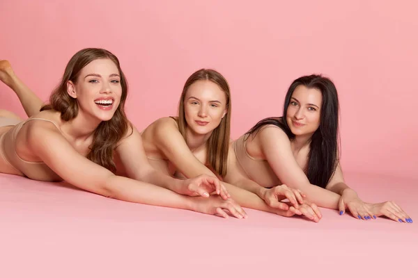 三个迷人的女孩的画像 穿着米色内装的女人披着粉红的背景 靠近点身体和皮肤护理的概念 健康饮食 整形手术 化妆品 — 图库照片