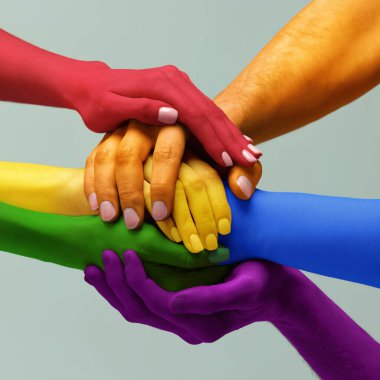 Closeup hands painted in different colors as rainbow flag holding together symbolizing tolerance unity love, LGBT on light background. Concept of LGBT, activism, community and freedom. clipart