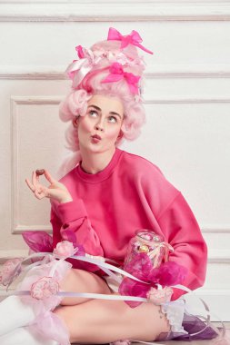 Tatlı Diş. Güzel bir kadın portresi, pembe peruk takan ve şeker yiyen bir kraliçe, lüks bir iç mekan üzerinde tatlılar. Devir, modernlik ve rönesans, güzellik ve tarih karşılaştırması kavramı