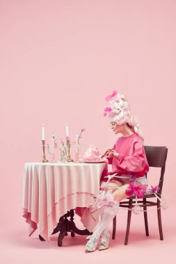 Kraliyet kahvaltısı. Zarif prensesin portresi, pembe elbiseli kraliçe ve pembe arka planda peruk yiyen kadın. Devir, modernlik ve rönesans, güzellik ve tarih karşılaştırması kavramı
