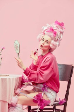 Ördek dudağı. Çekici prensesle portre, peruk takmış, el aynası tutan ve pembe arka planda ruj kullanan bir kraliçe. Devir, modernlik ve rönesans, güzellik ve tarih karşılaştırması kavramı