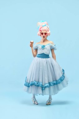 Prensesle portre, zarif elbiseler giyen kraliçe elinde dondurma, mavi arka planda şaşkın bir yüz var. Devir, modernlik ve rönesans kavramı, barok tarzı, güzellik, moda