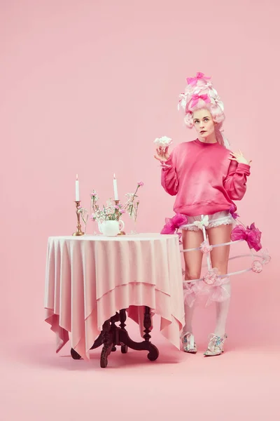 stock image Pink style birthday. Portrait with dreaming princess wearing fancy clothes holding cocktail over studio background. Comparison of eras, modernity and renaissance, fashion, beauty, party, celebration