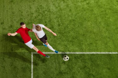 İki adam, futbol oyuncuları profesyonel stadyumda futbol oynuyorlar. Bütün oyuncular markasız kıyafetler giyer. Profesyonel spor anlayışı, takım oyunu, rekabet, şampiyonluk, reklam