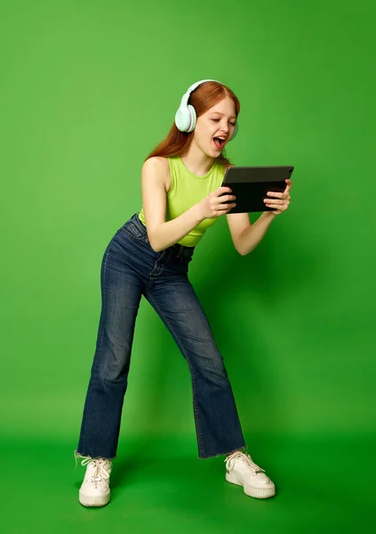 비디오 헤드폰을 태블릿을 스크린을 관심있는 얼굴로 소녀의 음악에 — 스톡 사진