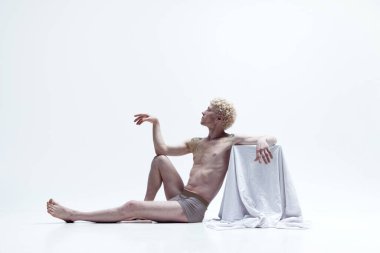 Beyaz stüdyo arka planında izole edilmiş heykel gibi üstsüz poz veren antika bir adamın portresi. Erkek vücudu estetiği, erkek güzelliği, ilham, sanat, reklam kavramı