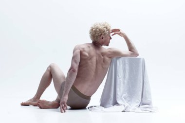 Antika heykel. Heykelde poz veren kaslı adam beyaz stüdyo arka planında çıplak poz veriyor. Arkadan bak. Erkek vücudu estetiği, doğal güzellik, erkek güzelliği, ilham, sanat konsepti.