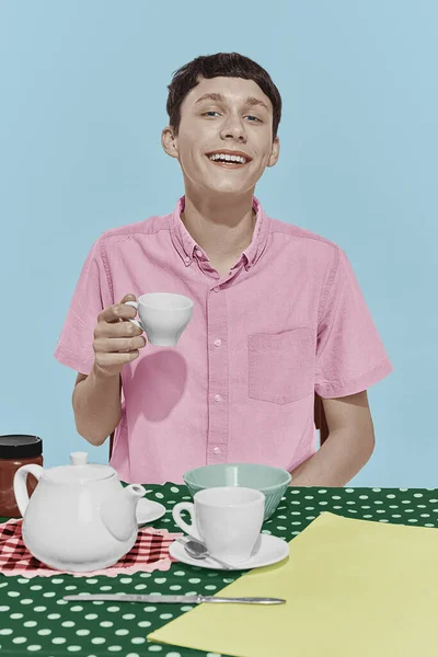 Fiatal Boldog Fiú Asztalnál Reggelizik Mosolyog Fehér Stúdió Hátterében Szivárvány — Stock Fotó