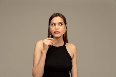 Yüzünün bir kısmını tutan genç ve güzel bir kız. Şok ve şaşkınlık içeriyor. Yaratıcı kolaj. İnsan duyguları, çeşitlilik, duygular, iç dünya, psikoloji, gençlik kavramı. Ad