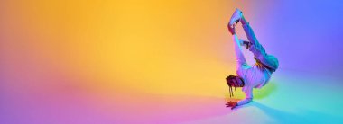 Spor elbiseli genç adam break dans yapıyor. Hip-hop, neon ışıkta arka plandaki gradyan stüdyoya karşı. Sokak dansı, moda, gençlik, hobi anlayışı. Pankart. İlan için alanı kopyala