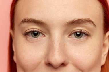 Kırmızı, seksi saçlı ve kameraya bakan büyük yeşil gözlü çekici genç kızın kırpılmış portresi. İyi korunmuş ciltli bir model. Güzellik, kaplıca, kozmetoloji, cilt bakımı, duygu konsepti