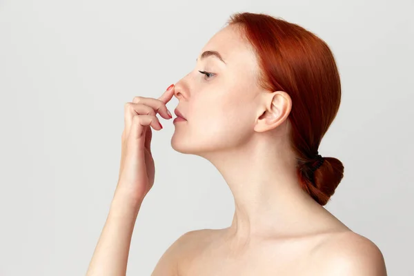 年轻的红头发女人 赤裸裸的肩膀 用手指触摸她的鼻子 鼻成形术 整形手术 美容标准 广告概念 — 图库照片