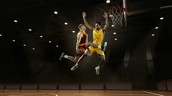 コラージュ 3Dモデルスポーツアリーナでバスケットボールボールと行動中のプロの2人のバスケットボール選手 ライバル ゲーム スポーツ 広告の概念 チームカラーを身に着けている選手スポーツウェア — ストック写真
