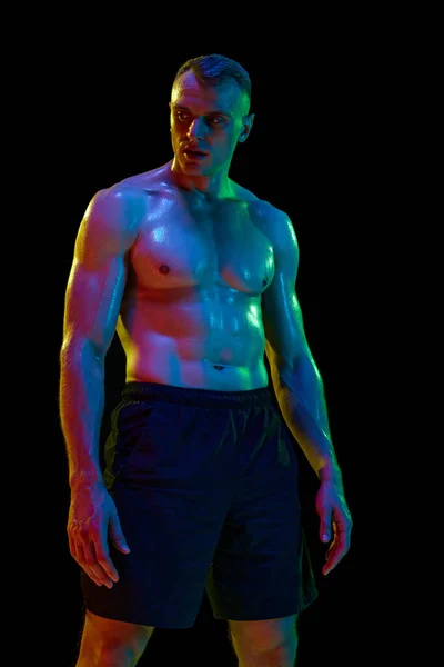 英俊的男人 肌肉发达 赤身裸体 在霓虹灯下面对着黑色的工作室背景 艰苦的训练体育 力量和速度的概念 — 图库照片