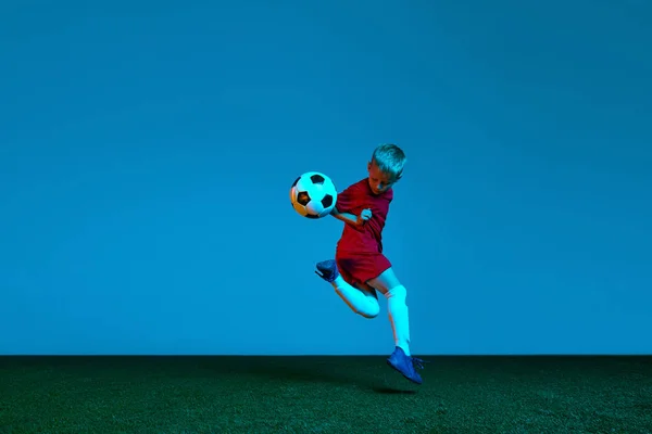 Studio Zdjęcie Małego Chłopca Piłkarza Mundurze Sportowym Skaczącego Piłką Nożną — Zdjęcie stockowe
