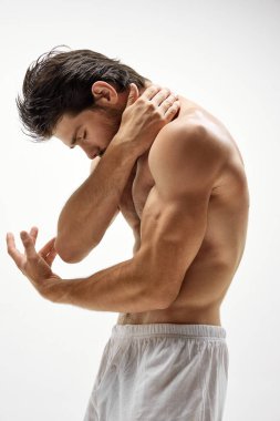 Beyaz arka planda yalnız poz veren pamuklu iç çamaşırı giyen kaslı erkek manken. Erkeklik. Erkek sağlığı, güzellik, vücut ve cilt bakımı, fitness ve reklam kavramı.