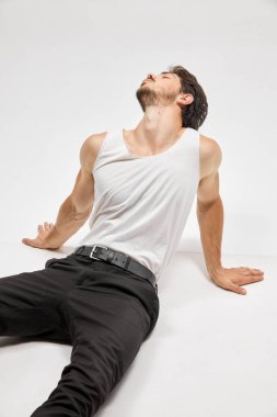 Stüdyonun arka planında izole edilmiş yakışıklı, koyu renk saçlı bir adamın portresi. Erkek doğal güzelliği. Erkek sağlığı, poz verme, güzellik, vücut ve cilt bakımı kavramı. Şık görünüş.