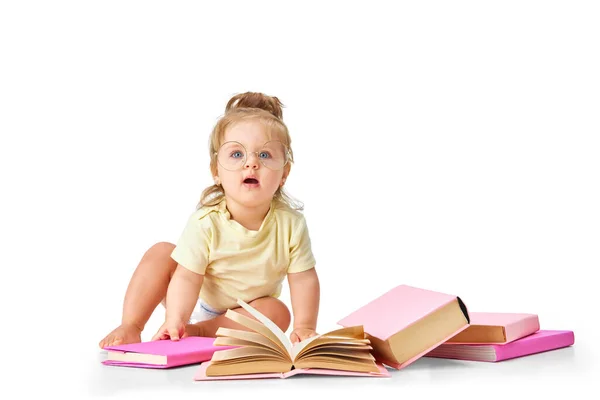 賢くて好奇心の強い赤ん坊 小さな女の子 幼児は白いスタジオの背景に対して多くの本で床に座っています 子供時代 誕生の概念 広告のコピースペース — ストック写真