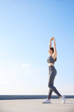 Spor ve meditasyon. Rahat spor giyim antrenmanında genç, sıcacık bir günde dışarıda esneme hareketleri yapan zayıf bir kadın. Spor anlayışı, aktif ve sağlıklı yaşam tarzı, güzellik, fitness, reklam