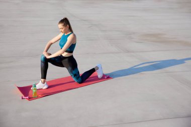 İnce, formda bir vücut eğitimi almış, sıcacık yaz günlerinde spor salonu eğitimi alan genç bir kadının en iyi görüntüsü. Esneme ve yoga. Spor anlayışı, aktif ve sağlıklı yaşam tarzı, güzellik, fitness, reklam