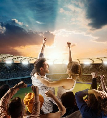 Zafer, kazanmak. Futbol taraftarları takımlarını destekliyor, birkaç erkek ve kadın bağırıyor, akşam sporu sahasında takımın adını haykırıyorlar. Spor, duygu, rekabet ve başarı kavramı.