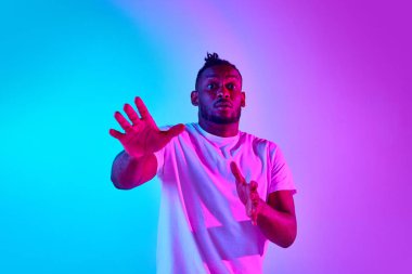 Korkmuş ve Afrikalı bir adam Neon 'daki renkli stüdyo geçmişinden kameraya bakıyor. İnsan duyguları kavramı, fuarlar, fobiler, reklam