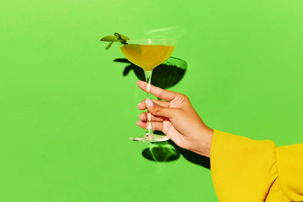 酒精饮料 手握高玻璃杯 配以黄铜鸡尾酒和明亮的绿色背景 流行艺术 派对和放松的概念 广告的复制空间 — 图库照片