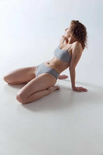 Schöne Frau Unterwäsche Posiert Auf Knien Auf Weißem Hintergrund Konzept — Stockfoto