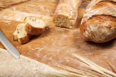 Tahta kesme tahtasıyla dilimlenmiş taze pişmiş ciabatta ekmeği. Sağlıklı yeme, beslenme ve el işi ürünü kavramı.