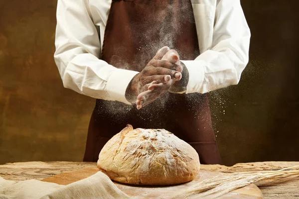 Nierozpoznawalny Piekarz Broundowym Fartuchu Wylewający Mąkę Okrągły Bochenek Chleba Brązowe — Zdjęcie stockowe