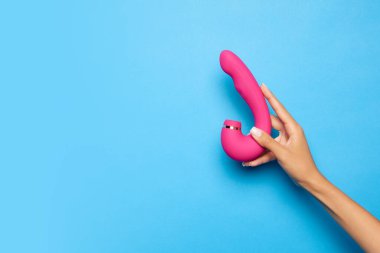 Kadınların elinde vibratör, mavi arka planda tıbbi masaj aleti var. Seks dükkanı için görüntü. Sağlık kavramı, tıp. Reklam, metin için kopyalama alanı
