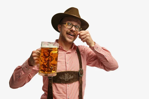 ハッピーに見える 帽子をかぶった魅力的な若者の肖像画は バイエルンの民俗服を着て ビールのマグカップを隔離された白い背景を持っています アルコール 広告コンセプト — ストック写真