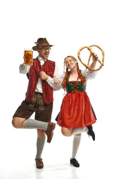 バイエルンのビールグラスと巨大なプレッツェルでフォークフェスティバルの衣装を着ている感情的な男女の完全な長さの肖像画 アルコール 祭りの概念 Adのためのスペースをコピーする — ストック写真