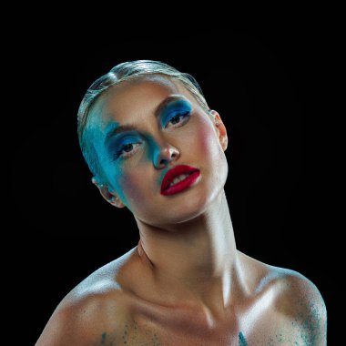 Güzel, şehvetli, sarışın, omuzları açık, yüzünde şenlik makyajı olan bir kız. Abartılı sanat makyajı yapmış genç bir kadın. Tatil, kutlama, kozmetik, moda ve güzellik kavramı.