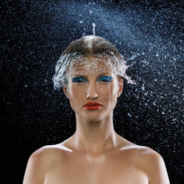 Yüzünde parlak ve renkli makyajı olan çekici bir genç kız ve su akıntısı karanlık modu izole etti. Sağlık ve cilt bakımı, güzellik, moda, sanat kavramı. Ad