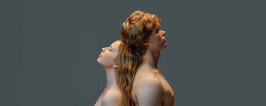 Havalı, çekici, kızıl saçlı bir çift, yakışıklı bir adam ve stüdyoda arka arkaya duran çıplak omuzlu güzel bir kadın. Doğal güzellik kavramı, aşk, ilişkiler, moda. Reklam. Pankart