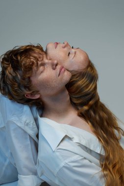 Destek. Çekici kızıl saçlı çift, yakışıklı adam ve güzel kadın tişört giymiş stüdyo da gözleri kapalı sırt sırta oturuyorlar. Doğal güzellik kavramı, aşk, ilişkiler, moda