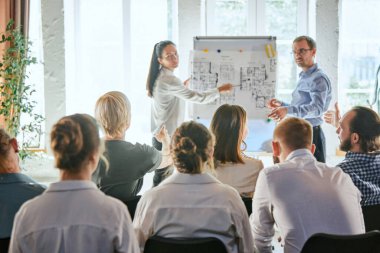 Kendine güvenen erkek ve kadın liderler, koçlar bir grup ofis çalışanıyla konuşuyor, iyi sohbet ediyorlar. Astlık kavramı, beyin fırtınası, iş stratejisi, fikirler, takım oluşturma.